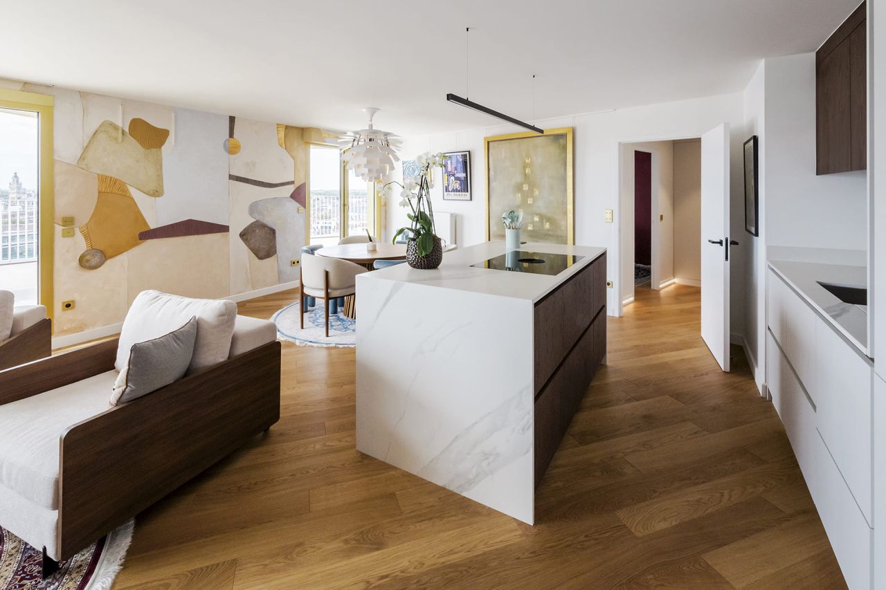 Redistribution appartement Lille : Vue panoramique sur le séjour ouvert, intégrant salon et cuisine Bulthaup pour maximiser la lumière et l'espace.